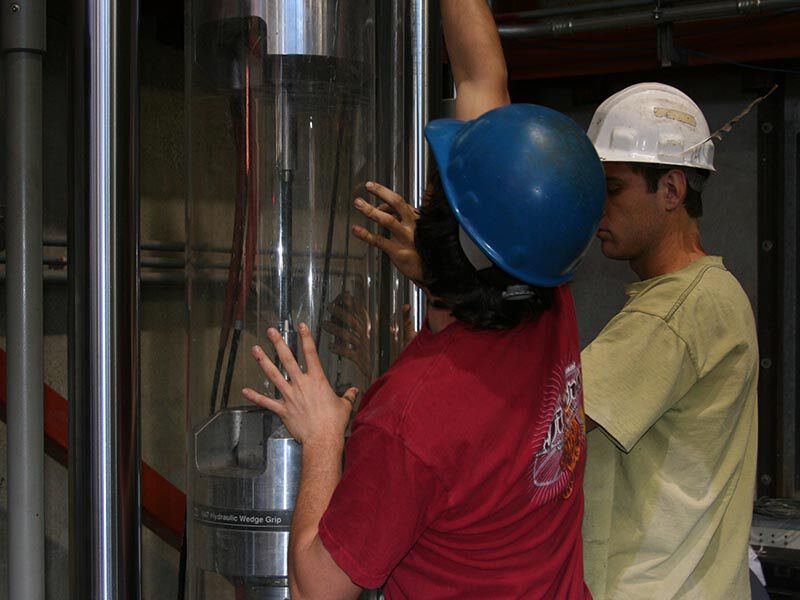 Megalex™ sucker rod in an industrial setup with two technicians.